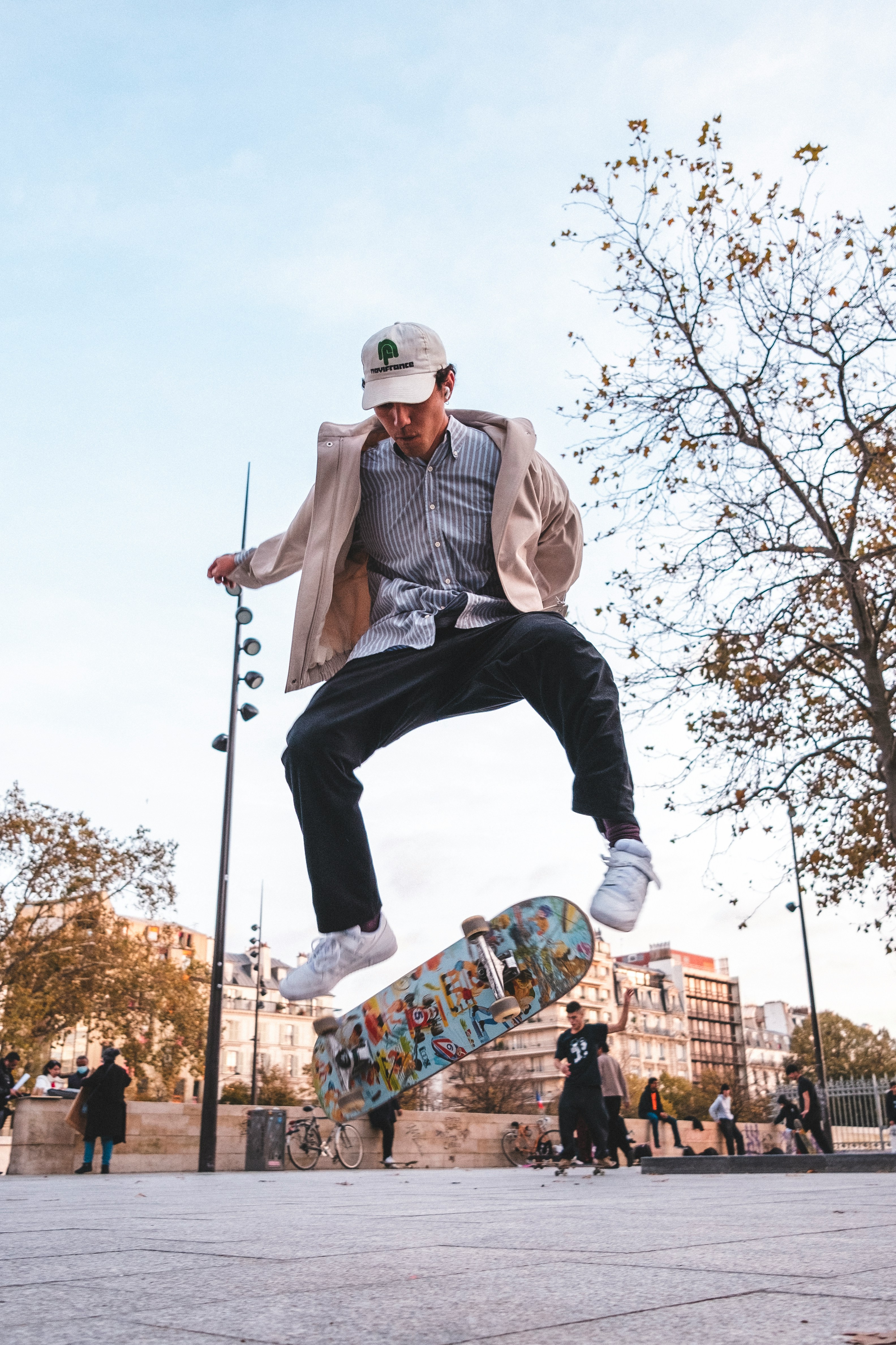 Skater mid-air over urban plaza in streetwear
