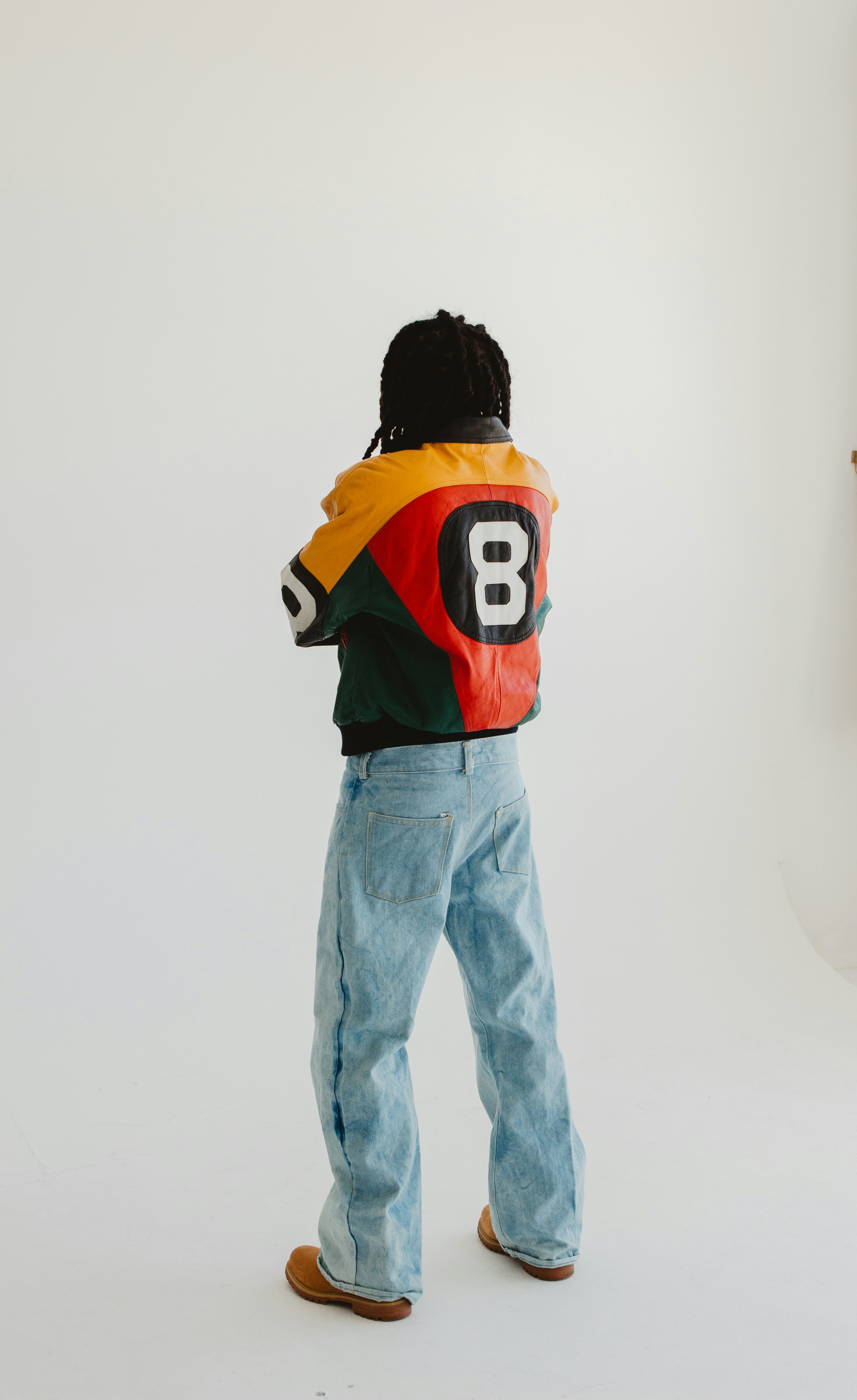8-ball bomber jacket and wide denim from behind